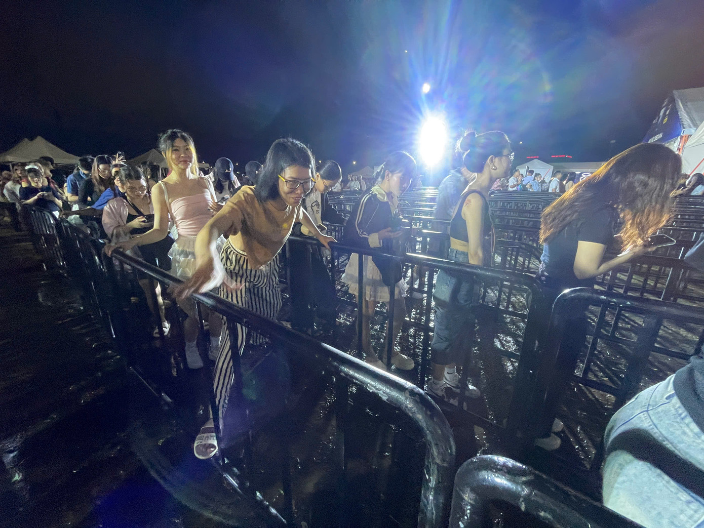 Khán giả vất vả leo hành lang phân hàng vì cơn mưa lớn lúc chiều gây đọng nước. Ảnh: Phạm Nguyễn. Khán giả vất vả leo hành lang phân hàng vì cơn mưa lớn lúc chiều gây đọng nước. Ảnh: Phạm Nguyễn.