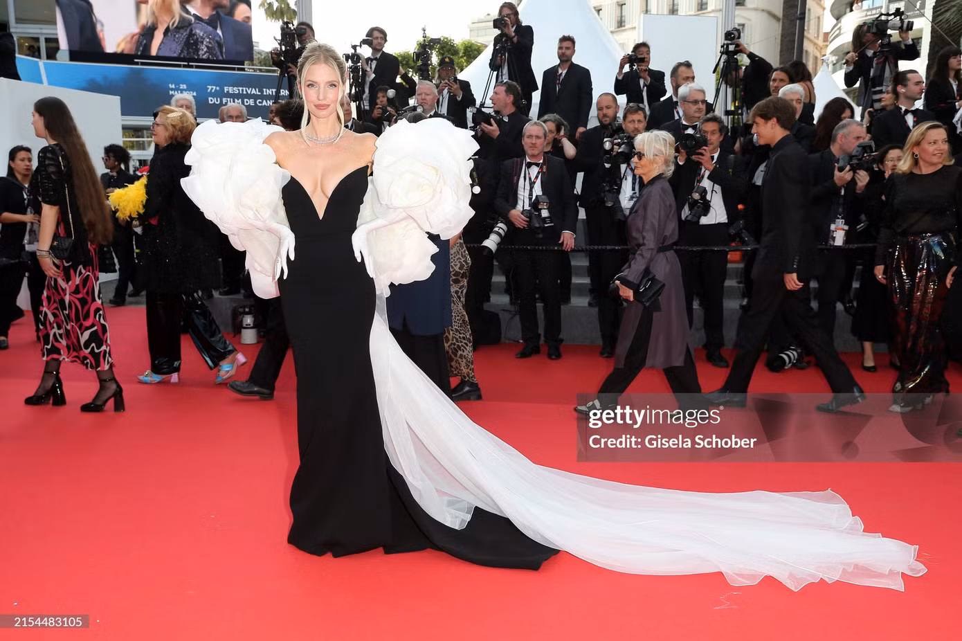 Fashionista người Đức - Leonie Hanne - chọn thiết kế khoét sâu phần ngực, phần tay bồng với chi tiết bông hoa khổng lồ cùng phần tà dài quét đất.
