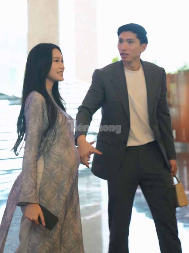 Cầu thủ Đoàn Văn Hậu nắm tay vợ Doãn Hải My cùng đến địa điểm tổ chức tiệc cưới. Cả hai trước đó đều dự hôn lễ của Quang Hải ở Đông Anh (Hà Nội). Ảnh: Trọng Tài.