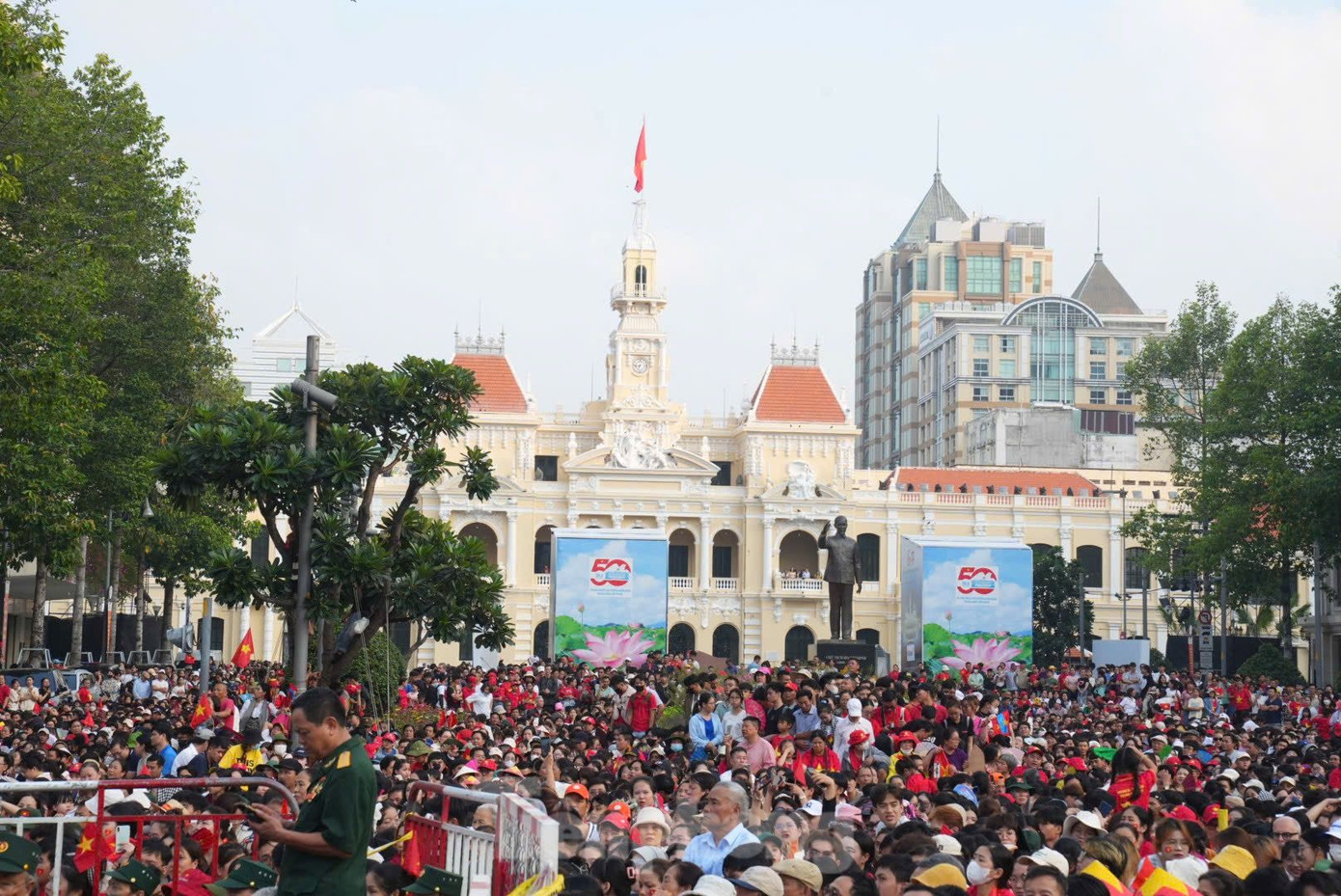 Người dân &quot;mở hội&quot; trên đường phố, cờ đỏ sao vàng phủ kín. Ai nấy đều mong tận mắt chứng kiến và hòa mình vào không khí trang nghiêm, hân hoan của lễ diễu binh, diễu hành mừng 50 năm ngày đất nước thống nhất.