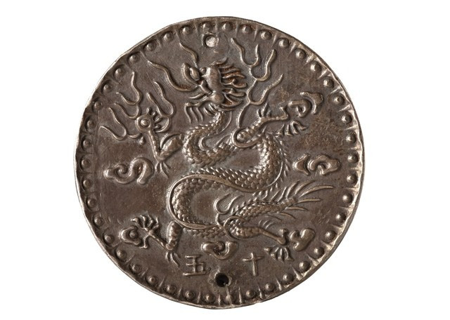 Bình hiệu đề Minh Mạng niên chế 1820-1841 (trái) và Tiền thưởng Phi long thập ngũ bạc Triều Nguyễn có hình ảnh rồng. Ảnh: Bảo tàng Lịch sử TP. Hồ Chí Minh.