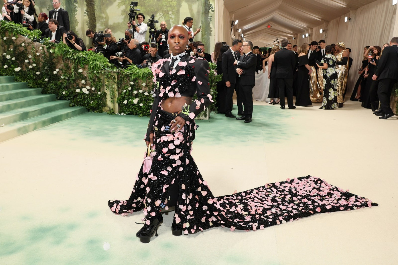 Cynthia Erivo bước đi trên thảm đỏ trong bộ đồ Thom Browne. Diện mạo đặc biệt của cô được bao phủ bởi 2.000 cánh hoa hồng lụa moiré với những hạt cườm được khâu tỉ mỉ trên khắp áo sơ mi.