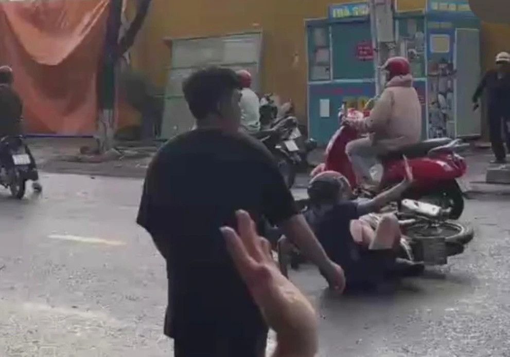 Một số người đi xe máy bị té ngã trên đường Phan Trung ở thành phố Biên Hòa.