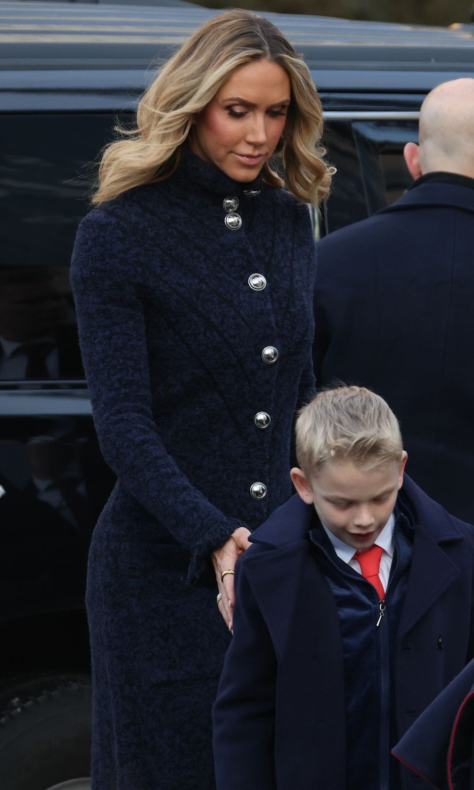 Con dâu Tổng thống đắc cử Mỹ Donald Trump - Lara Trump, vợ của Eric Trump và cựu đồng chủ tịch Ủy ban Quốc gia Đảng Cộng hòa, giữ phong cách đơn giản với chiếc áo khoác ôm sát màu xanh navy, điểm nhấn là những chiếc cúc bạc lớn, kết hợp với đôi giày cao gót Christian Louboutin đen.