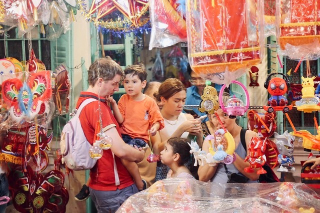 Một gia đình người nước ngoài cũng đưa con em tới Phố lồng đèn để vui chơi dịp Tết Trung thu.