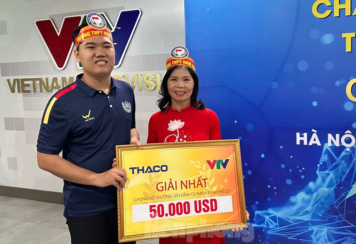 Anh trai Lê Xuân Mạnh - Lê Xuân Dương (trái) cùng mẹ, bà Vũ Thị Hường (phải) vui mừng &quot;check-in&quot; bên phần thưởng 50.000 USD - giải thưởng cao nhất trong 23 năm qua của chương trình Đường lên đỉnh Olympia. Ảnh: Như Ý