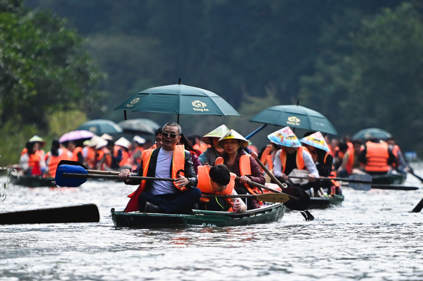 Trời nắng, nhiều gia đình có trẻ nhỏ trang bị thêm ô, trùm kín áo mũ để tránh nắng trong thời gian gần 2 tiếng vãn cảnh.