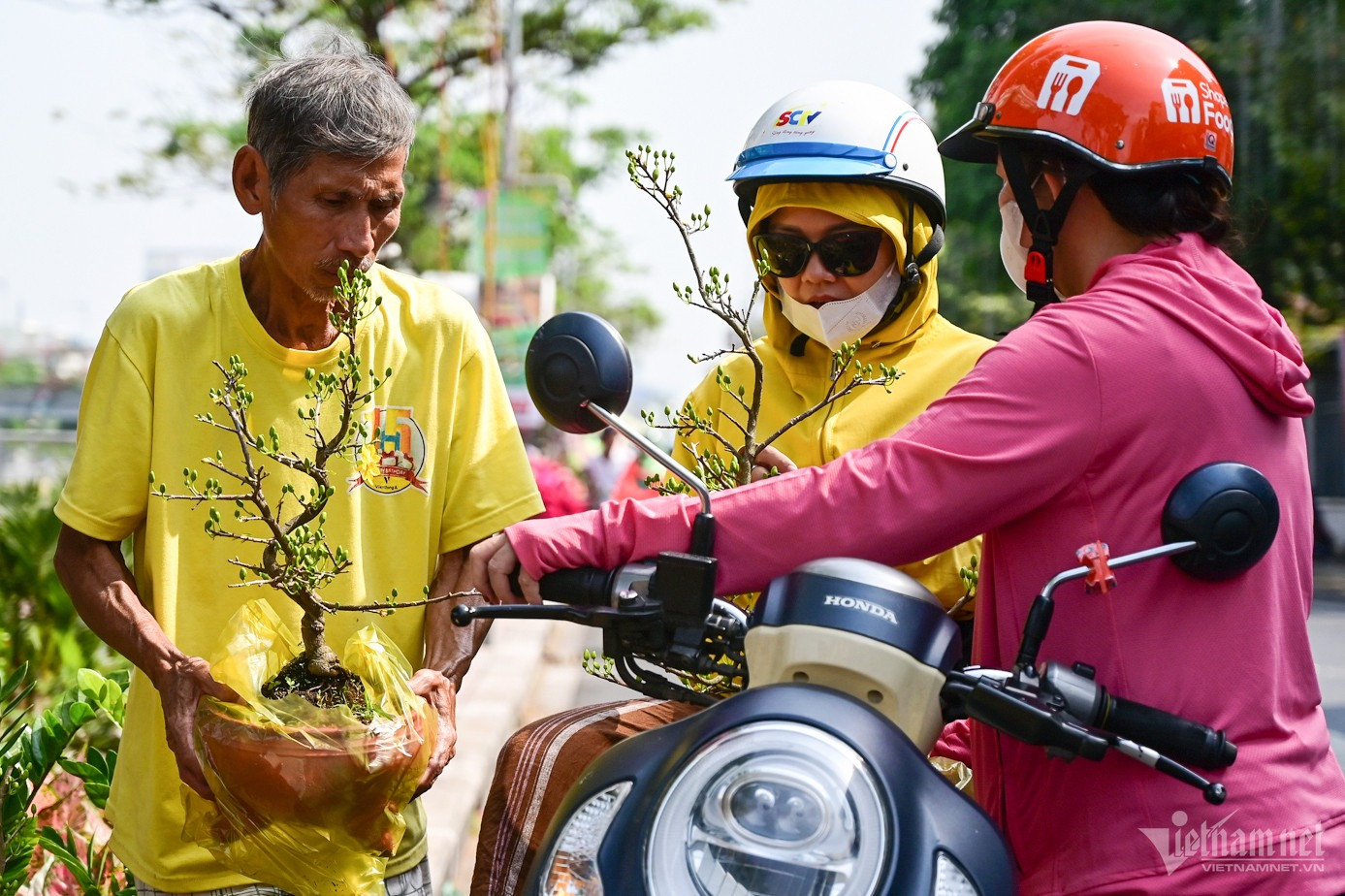 Chị Thư (quận 8) chốt mua 2 chậu mai vàng với giá 600.000 đồng sau một hồi ngắm. "Mình chỉ muốn mua cây nhỏ đặt trên bàn. Nhà gần đây nên sát Tết tôi sẽ ra mua thêm hoa", chị nói.