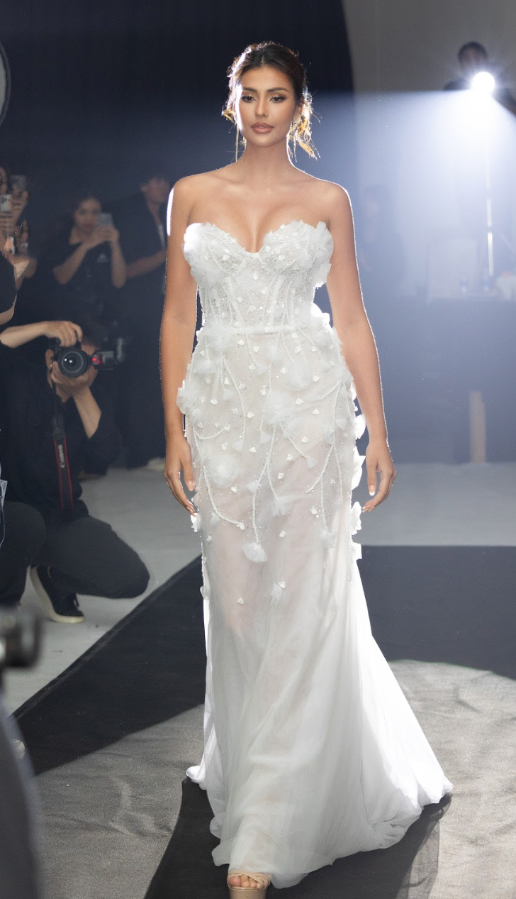 Á hậu sinh năm 1997 diện thiết kế váy cưới đuôi cá dài quét đất với phần cúp ngực khoe vai trần, họa tiết 3D đính kết hoa.