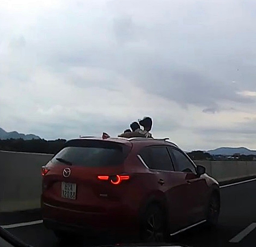 Ôtô mở cửa sổ trời cho trẻ em ló đầu ra ngoài trên cao tốc vô cùng nguy hiểm. Ảnh cắt từ camera Ôtô mở cửa sổ trời cho trẻ em ló đầu ra ngoài trên cao tốc vô cùng nguy hiểm. Ảnh cắt từ camera