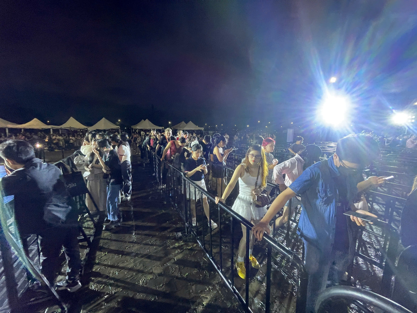 Khán giả vất vả leo hành lang phân hàng vì cơn mưa lớn lúc chiều gây đọng nước. Ảnh: Phạm Nguyễn. Khán giả vất vả leo hành lang phân hàng vì cơn mưa lớn lúc chiều gây đọng nước. Ảnh: Phạm Nguyễn.