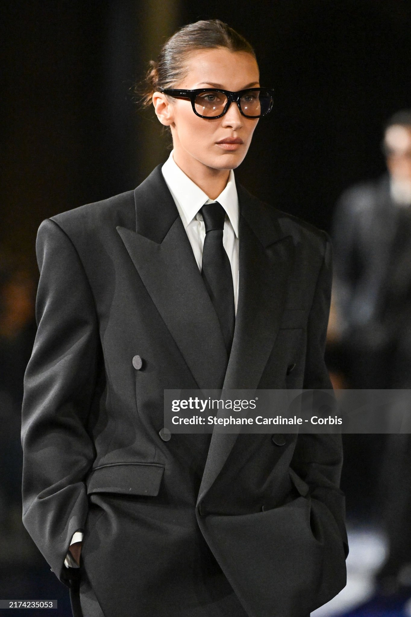 Đã hai năm kể từ lần cuối Bella Hadid sải bước trên sàn diễn. Siêu mẫu sải bước cùng đội hình Saint Laurent SS25 của Anthony Vaccarello. Trong bộ vest quyền lực rộng thùng thình, búi tóc vuốt ngược và cặp kính gọng đen dày, tạo hình của cô như vừa bước ra khỏi bộ phim mật vụ thập niên 1990. Ảnh: Getty. Đã hai năm kể từ lần cuối Bella Hadid sải bước trên sàn diễn. Siêu mẫu sải bước cùng đội hình Saint Laurent SS25 của Anthony Vaccarello. Trong bộ vest quyền lực rộng thùng thình, búi tóc vuốt ngược và cặp kính gọng đen dày, tạo hình của cô như vừa bước ra khỏi bộ phim mật vụ thập niên 1990. Ảnh: Getty.