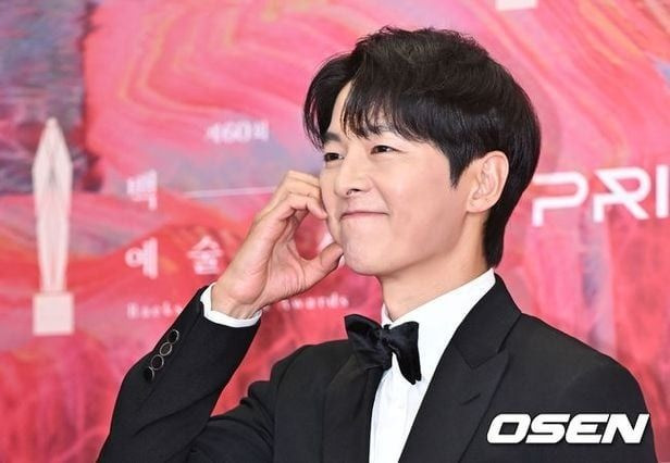 Song Joong Ki tạo dáng trái tim khi đi thảm đỏ Baeksang 2024. Ảnh: Osen.