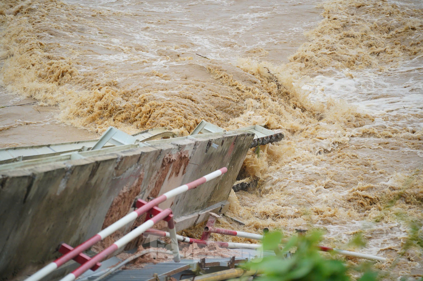Mảng cầu Phong Châu nằm dưới lòng sông nước chảy xiết. Nhiều người dân địa phương cho biết cầu có dấu hiệu bị nghiêng trụ và rung lắc trước khi sập 10 phút. Ảnh: Đức Nguyễn.