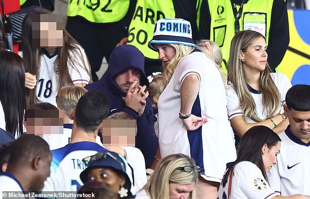 Luke Shaw quấn mình che lấp nỗi buồn trong chiếc áo hoodie, xung quanh là gia đình và bạn bè các cầu thủ.