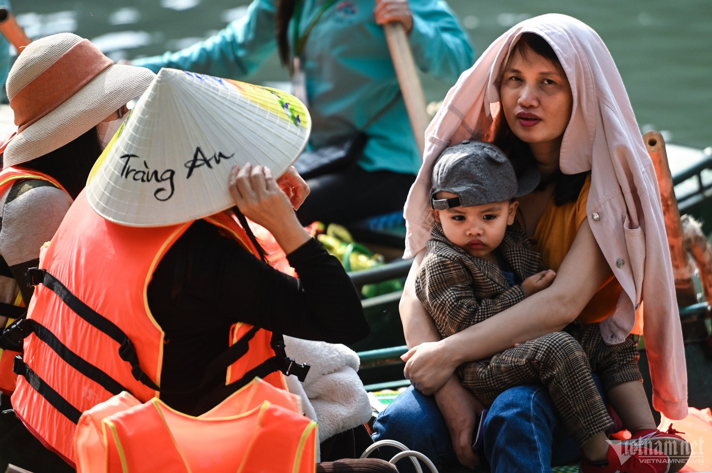 Trời nắng, nhiều gia đình có trẻ nhỏ trang bị thêm ô, trùm kín áo mũ để tránh nắng trong thời gian gần 2 tiếng vãn cảnh.