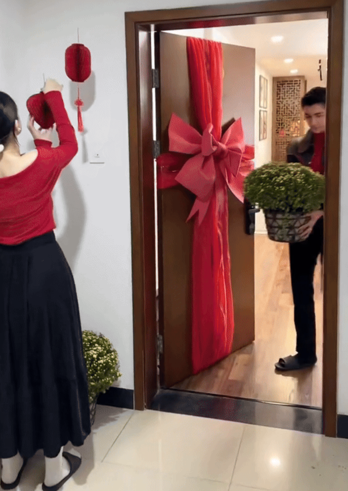 Vợ chồng Bình An - Phương Nga mua nhiều phụ kiện, chậu hoa trang trí nhà cửa đón năm mới. Gam màu đỏ chủ đạo, tạo cảm giác tươi mới, ấm cúng.