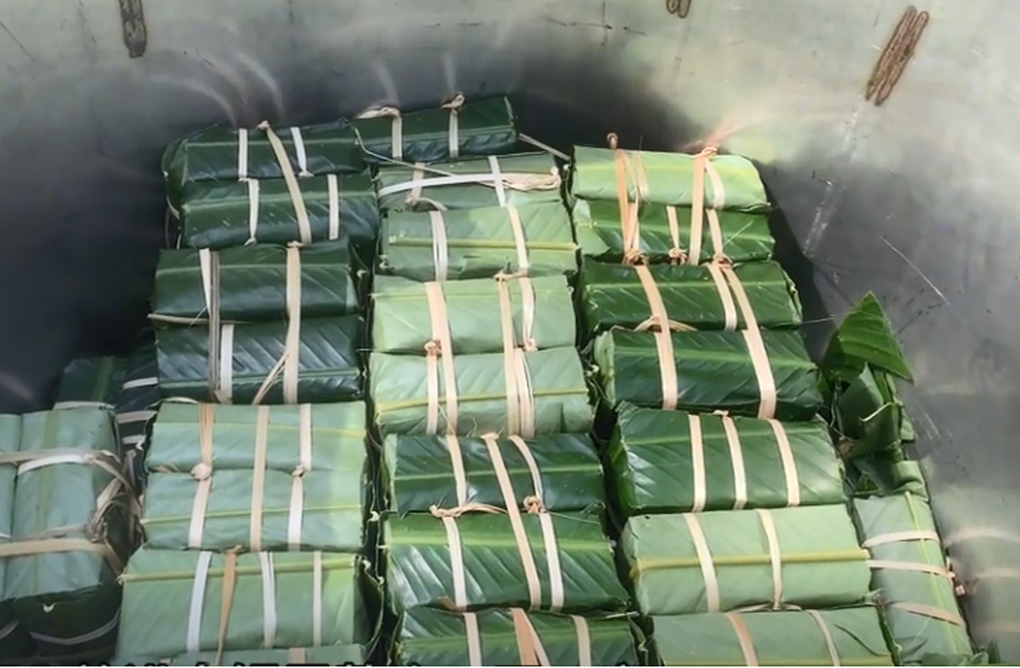 Các gia đình quây quần gói 100 chiếc bánh chưng (Ảnh cắt từ clip).