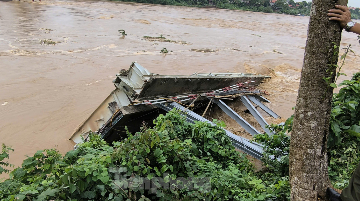 Mảnh nhịp cầu Phong Châu mắc lại bên bờ sau khi bị sập. Mảnh nhịp cầu Phong Châu mắc lại bên bờ sau khi bị sập.