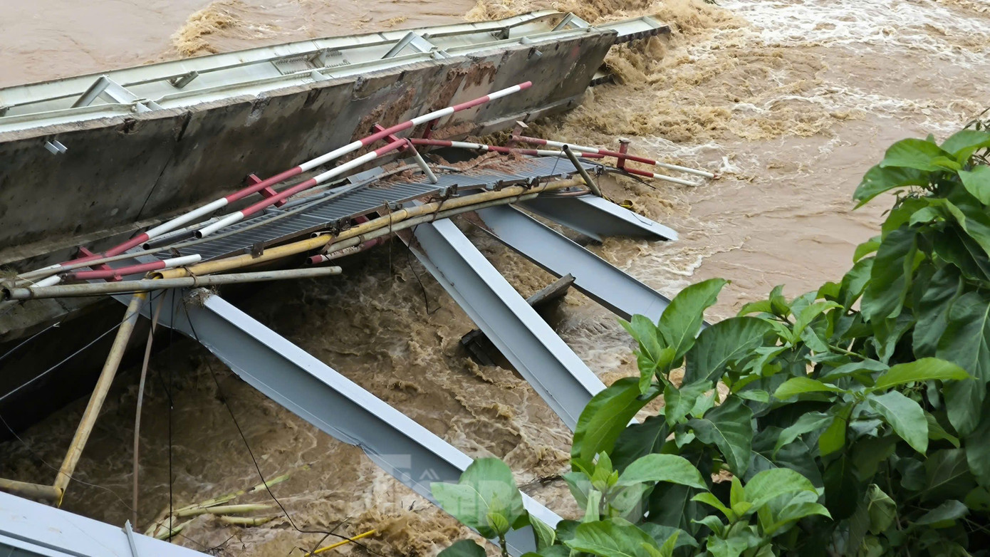 Mảnh nhịp cầu Phong Châu mắc lại bên bờ sau khi bị sập. Mảnh nhịp cầu Phong Châu mắc lại bên bờ sau khi bị sập.