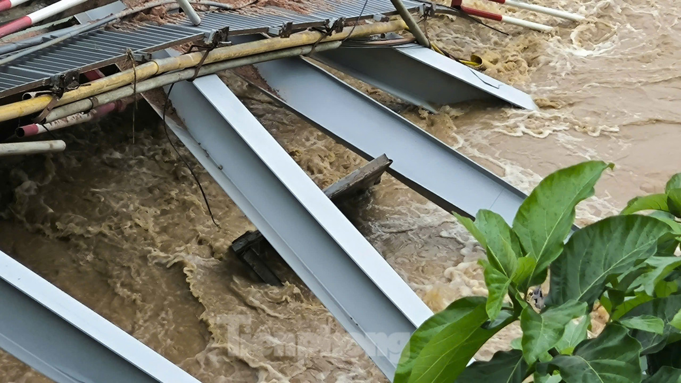 Mảnh nhịp cầu Phong Châu mắc lại bên bờ sau khi bị sập. Mảnh nhịp cầu Phong Châu mắc lại bên bờ sau khi bị sập.