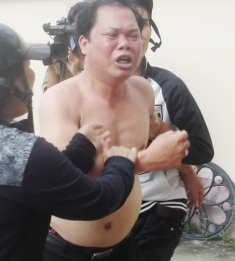 Phó phòng tư pháp Huỳnh Thanh Thắng (cởi trần) đã cướp súng, giật quân hàm, bảng tên của thiếu úy CSGT Phan Vĩnh Minh Ảnh: Nguyễn Văn Đức