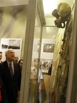 TNS John McCain bên bộ quần áo phi công ông từng mặc khi máy bay của ông bị bắn rơi. Ảnh AP.