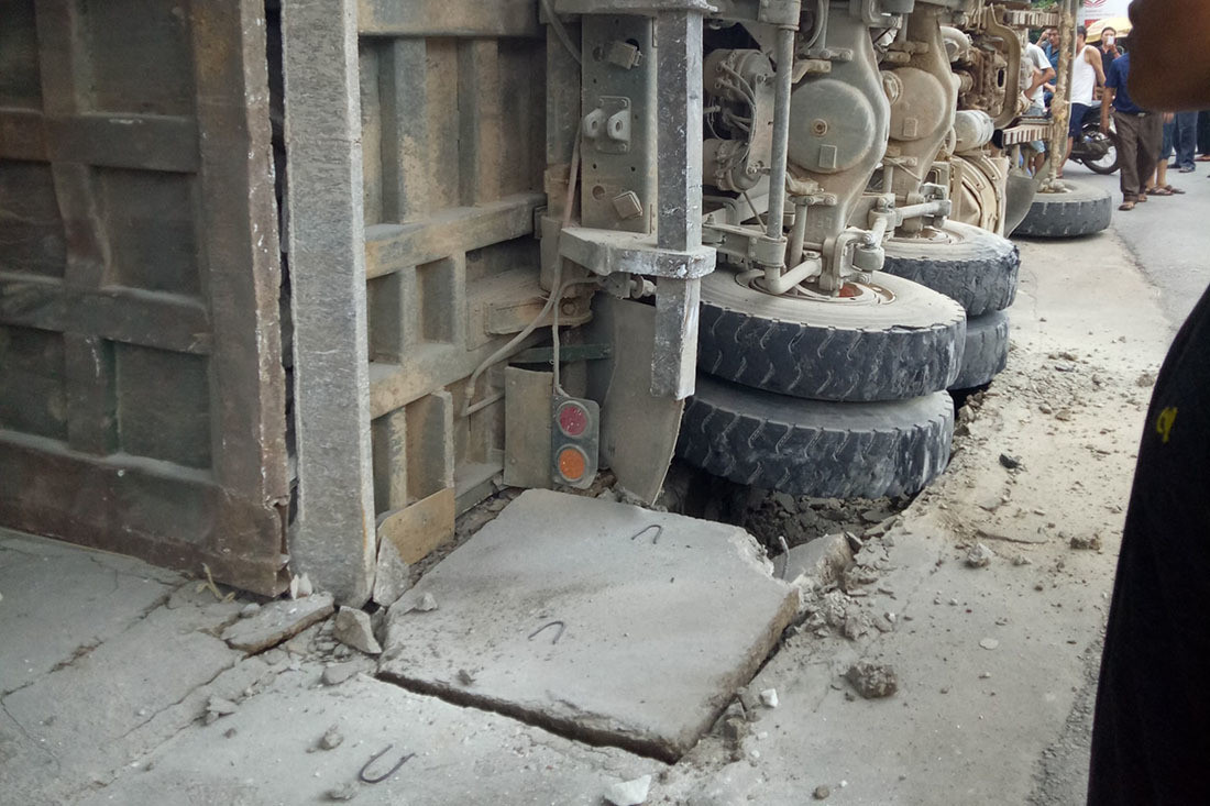 Xe chở đá bị lật nghiêng bên quốc lộ, đè sập nhà dân ảnh 1