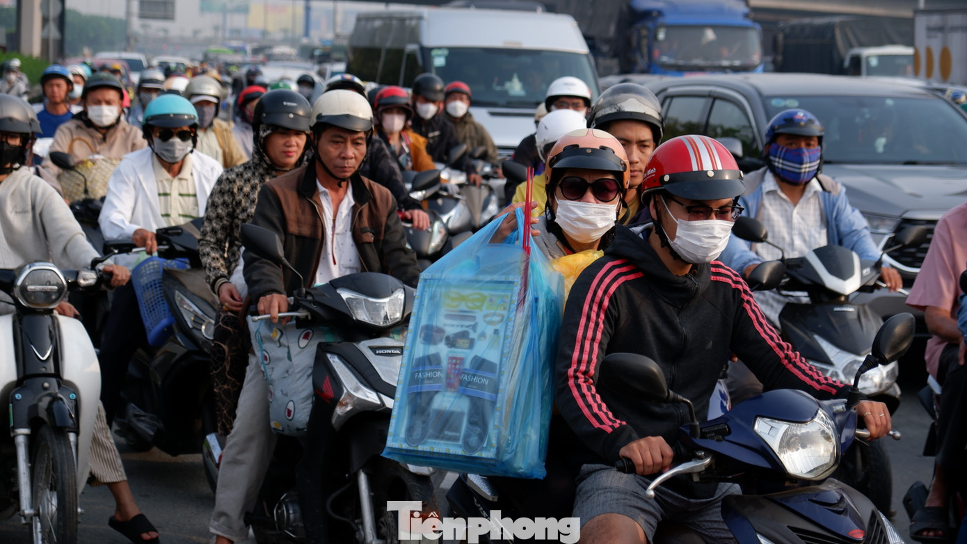 Người dân lỉnh kỉnh đồ đạc, rời TPHCM trên xe máy để về quê nghỉ Tết.