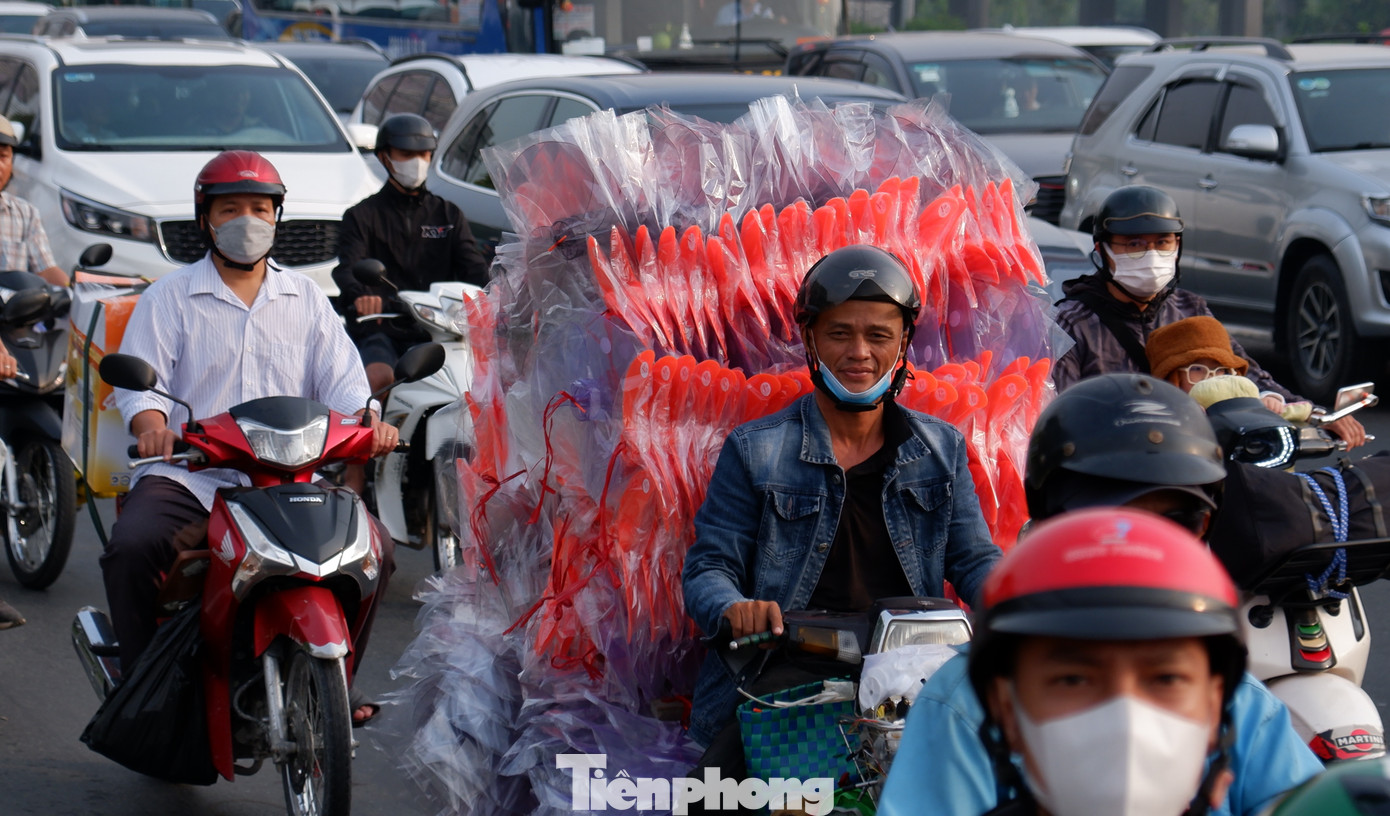 Người dân lỉnh kỉnh đồ đạc, rời TPHCM trên xe máy để về quê nghỉ Tết.