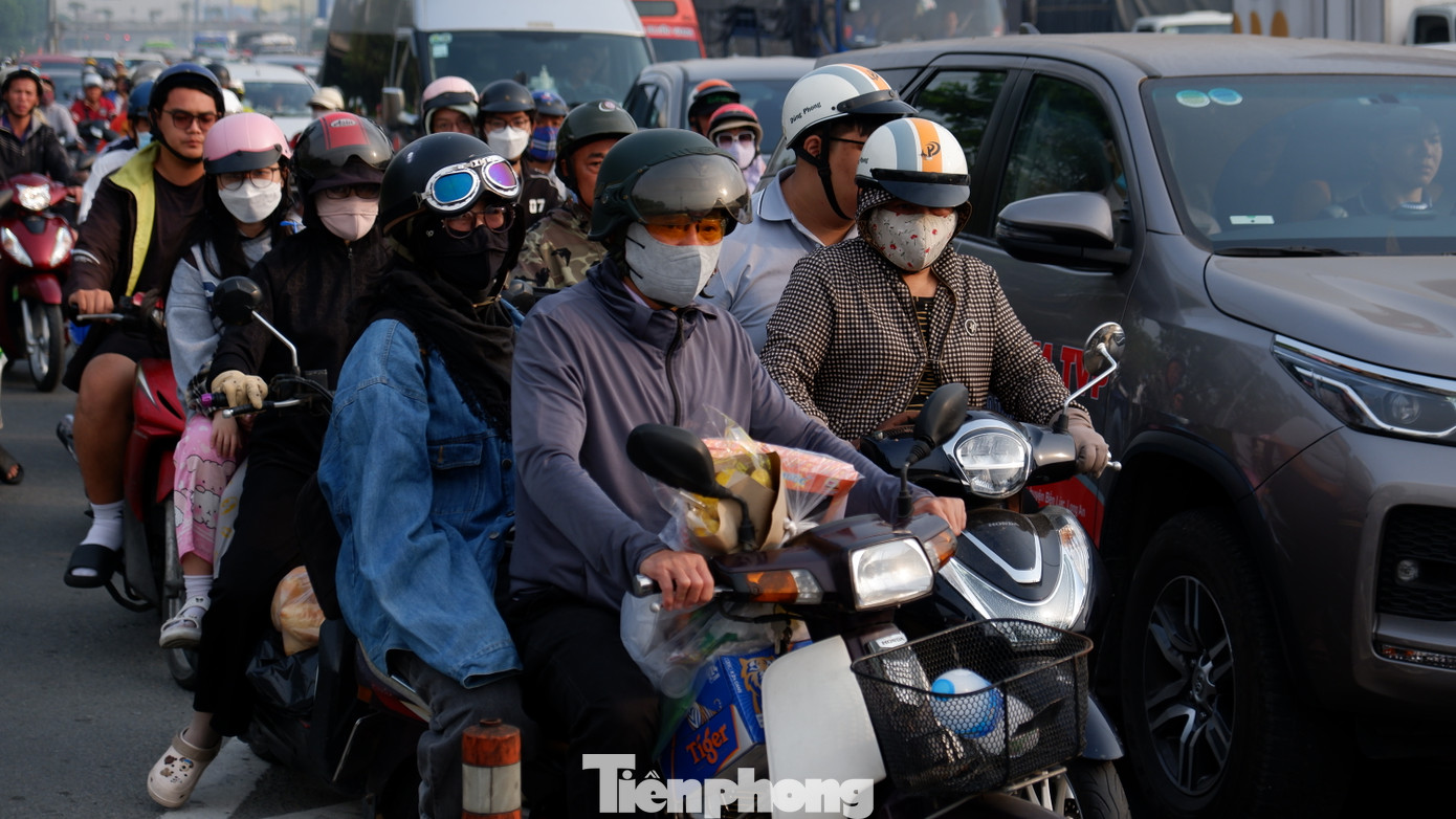 Người dân lỉnh kỉnh đồ đạc, rời TPHCM trên xe máy để về quê nghỉ Tết.