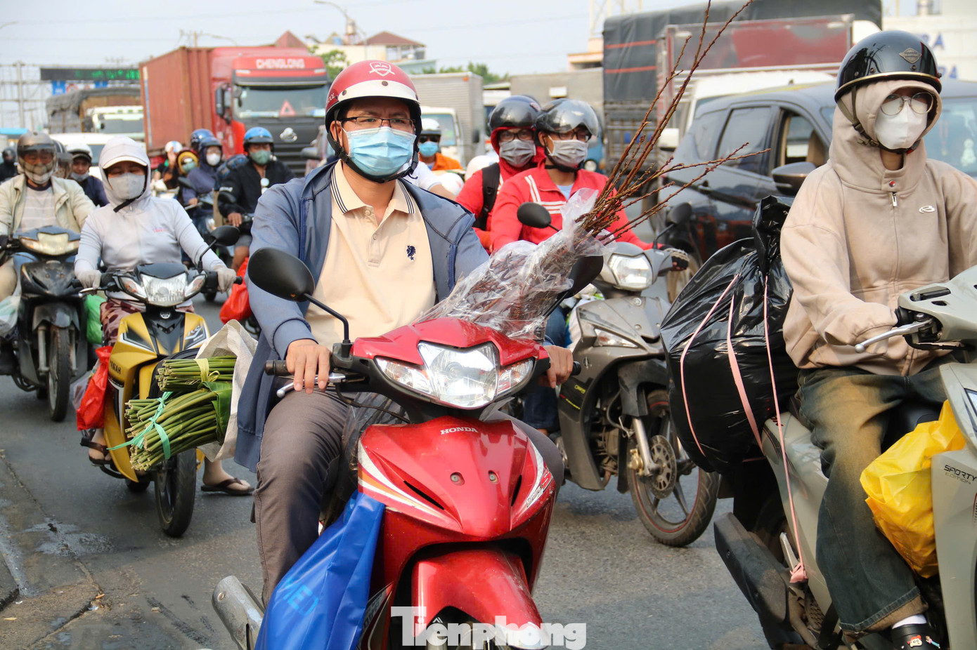 Người dân lỉnh kỉnh đồ đạc, hành lý, rời TPHCM trên xe máy để về quê nghỉ Tết.