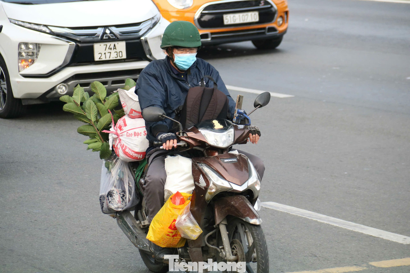 Người dân lỉnh kỉnh đồ đạc, hành lý, rời TPHCM trên xe máy để về quê nghỉ Tết.