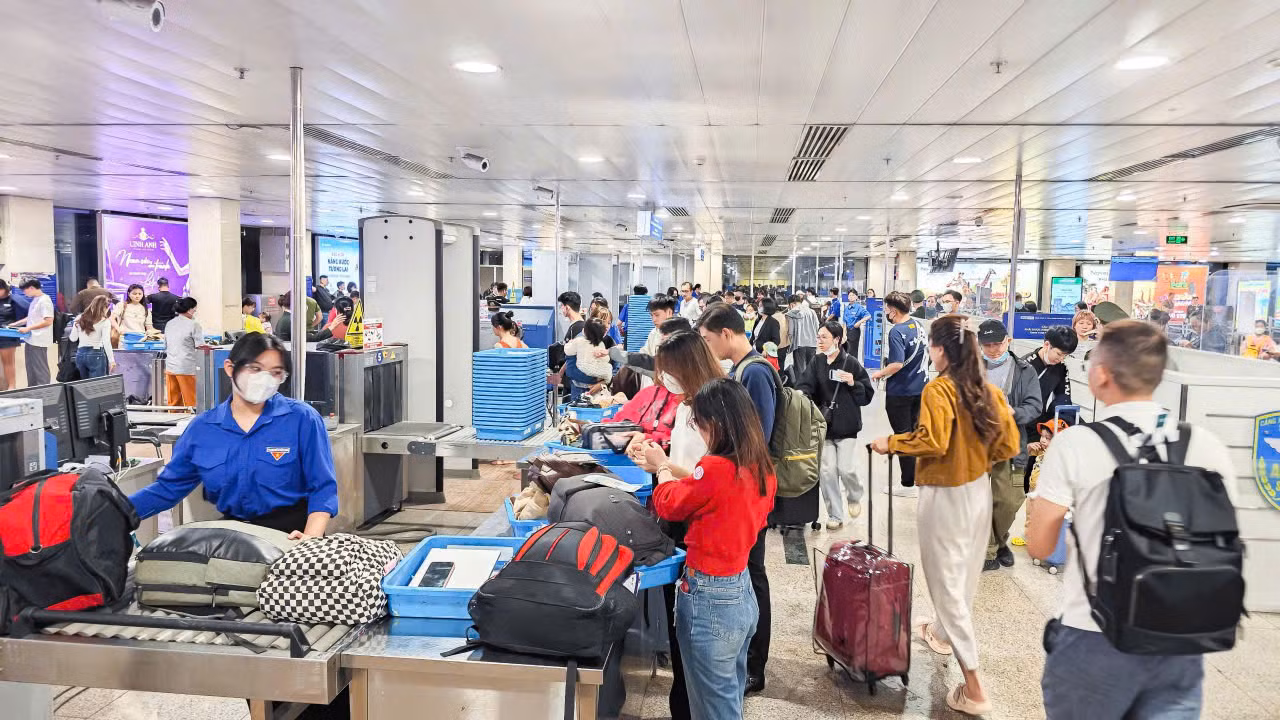Lực lượng đoàn viên thanh niên tham gia hỗ trợ hành khách ở khu vực soi chiếu hành lý.
