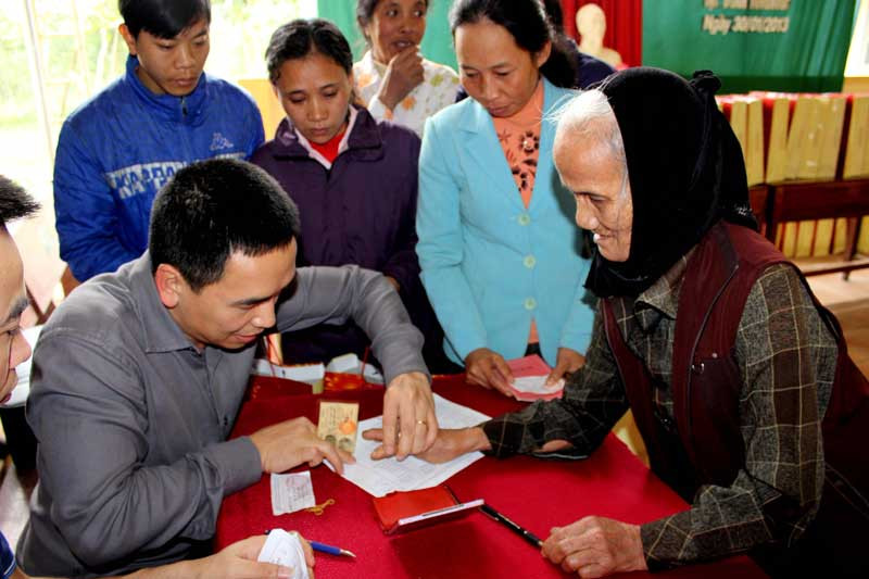 Cán bộ quỹ Thiện Tâm hướng dẫn bà Trần Thị Bảo điểm chỉ đề nhận quà