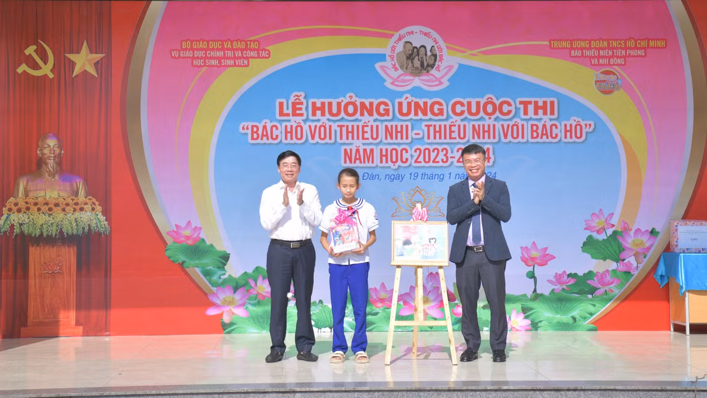 Ông Nguyễn Văn Thông - Phó Bí thư Thường trực Tỉnh ủy Nghệ An (bên trái) và nhà báo Nguyễn Phan Khuê - Tổng Biên tập Báo Thiếu niên Tiền phong và Nhi đồng trao giải Nhất cuộc thi vẽ tranh hưởng ứng Cuộc thi “Bác Hồ với thiếu nhi – Thiếu nhi với Bác Hồ”