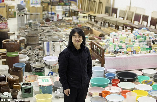 Nghệ sĩ Song Dong trước bộ sưu tập 10.000 sản phẩm của mình. Ảnh: DM