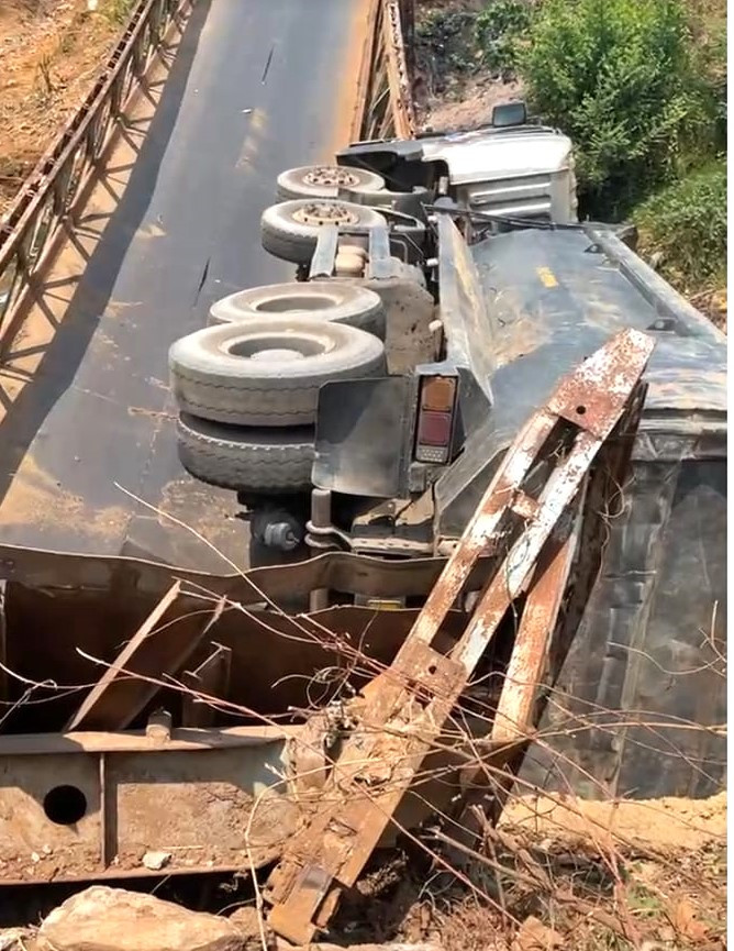 Chiếc xe ben lật nhào khi cầu sập Ảnh: D.M