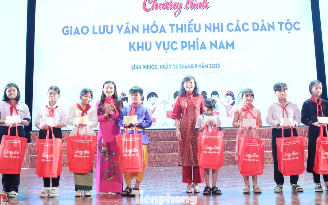 Bí thư Trung ương Đoàn, Chủ tịch Hội đồng Đội Trung ương Nguyễn Phạm Duy Trang (thứ tư từ trái sang) và Phó Bí thư Thường trực Tỉnh ủy, Chủ tịch HĐND tỉnh Bình Phước Huỳnh Thị Hằng (thứ năm từ phải sang) tặng quà cho thiếu nhi