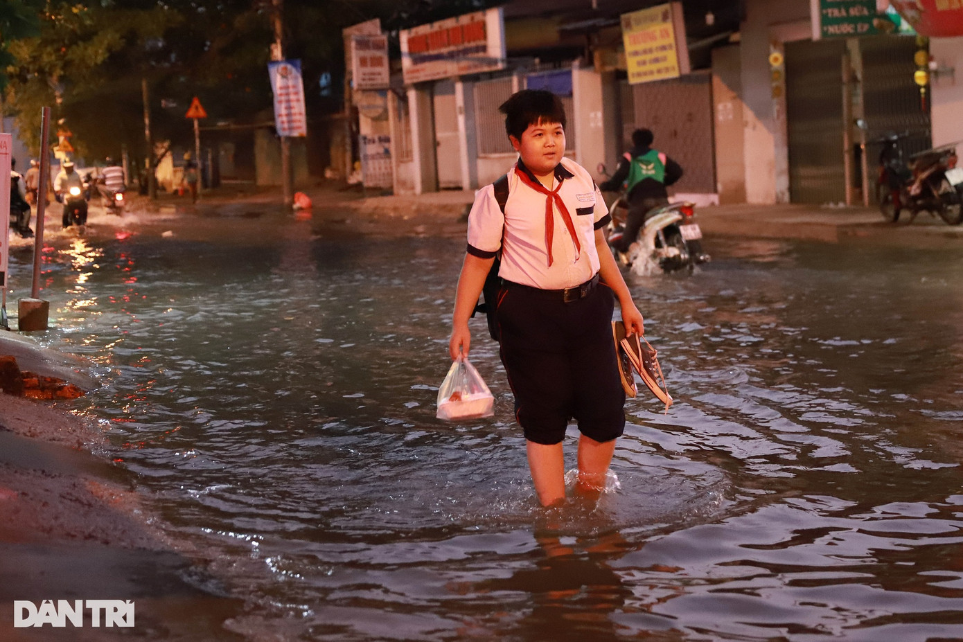 Một học sinh bì bõm trên đường đến trường khi nước triều dâng cao. Một học sinh bì bõm trên đường đến trường khi nước triều dâng cao.