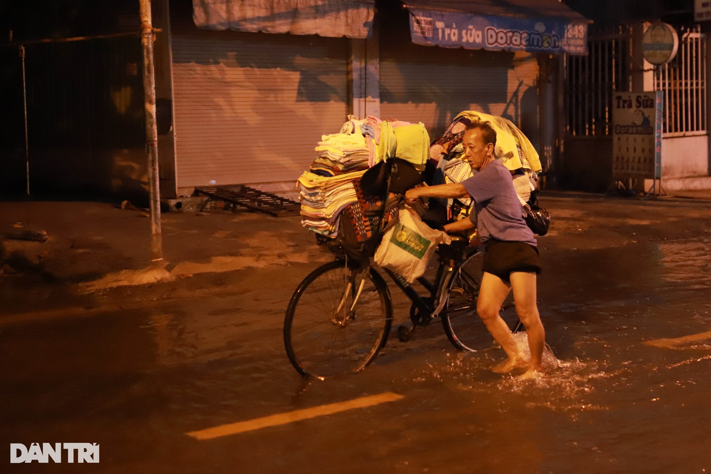 Để thuận lợi cho việc đi lại khi triều cường dâng cao, một người bán quần áo tranh thủ đẩy xe hàng ra chợ bày bán từ sớm. Để thuận lợi cho việc đi lại khi triều cường dâng cao, một người bán quần áo tranh thủ đẩy xe hàng ra chợ bày bán từ sớm.