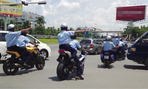 Đoàn vệ sĩ bảo vệ giơ gậy, chặn xe di chuyển để cho đoàn của Nick Vujicic qua trong chiều 22/5