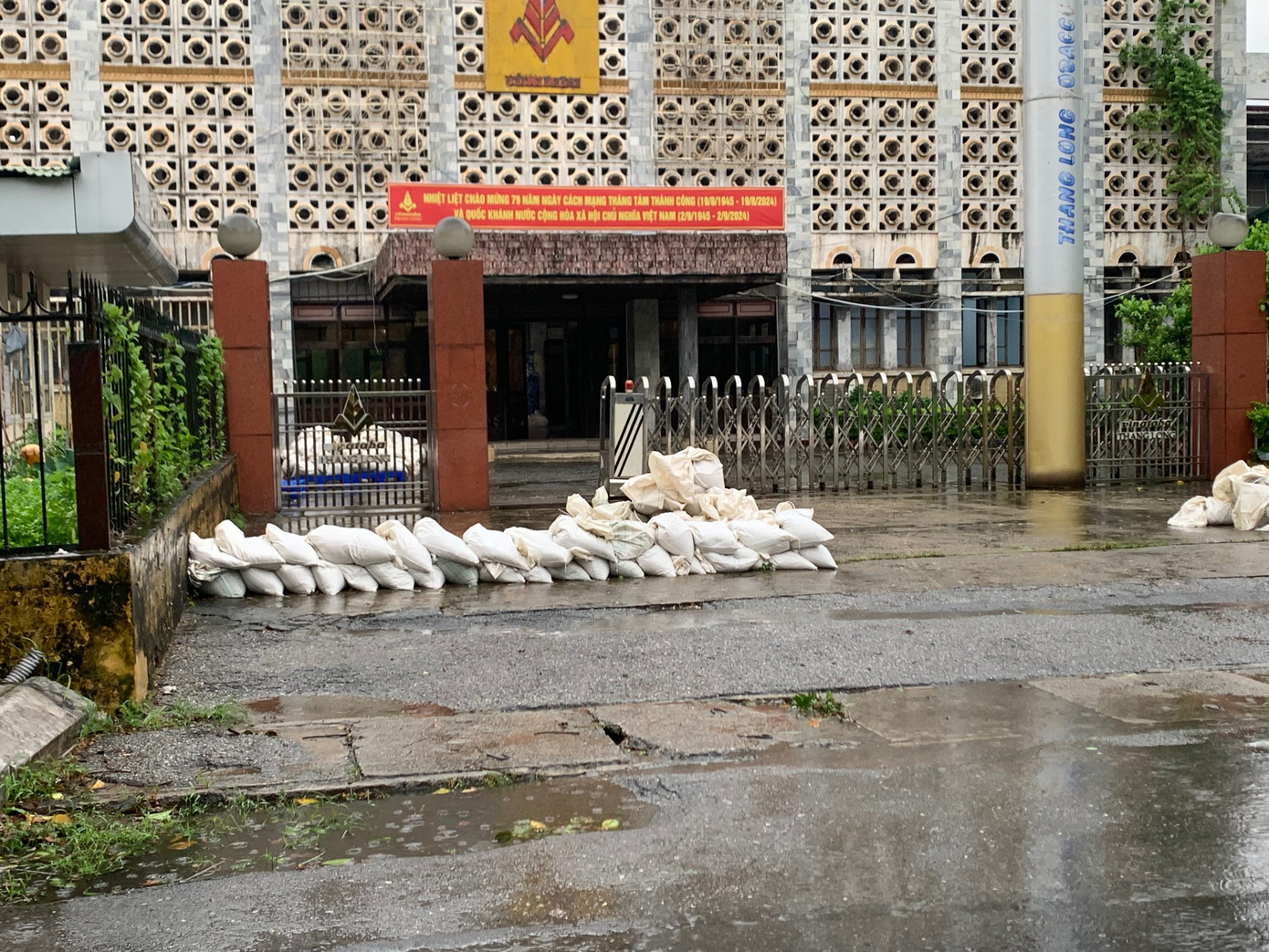 Đắp bao cát phòng ngập lụt trước cửa nhà máy trên đường Nguyễn Trãi, Hà Nội, chiều 7/9. Ảnh: Thái An.