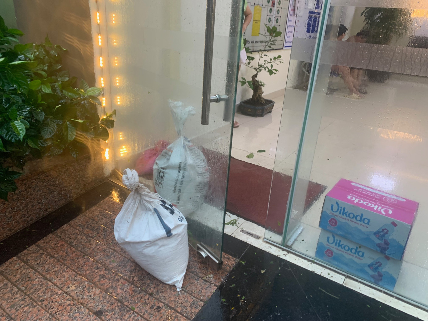 Dùng bao cát chặn cửa kính trước cửa tòa nhà khu dân cư gần phố Trần Điền, Hà Nội, chiều 7/9. Ảnh: Thái An.