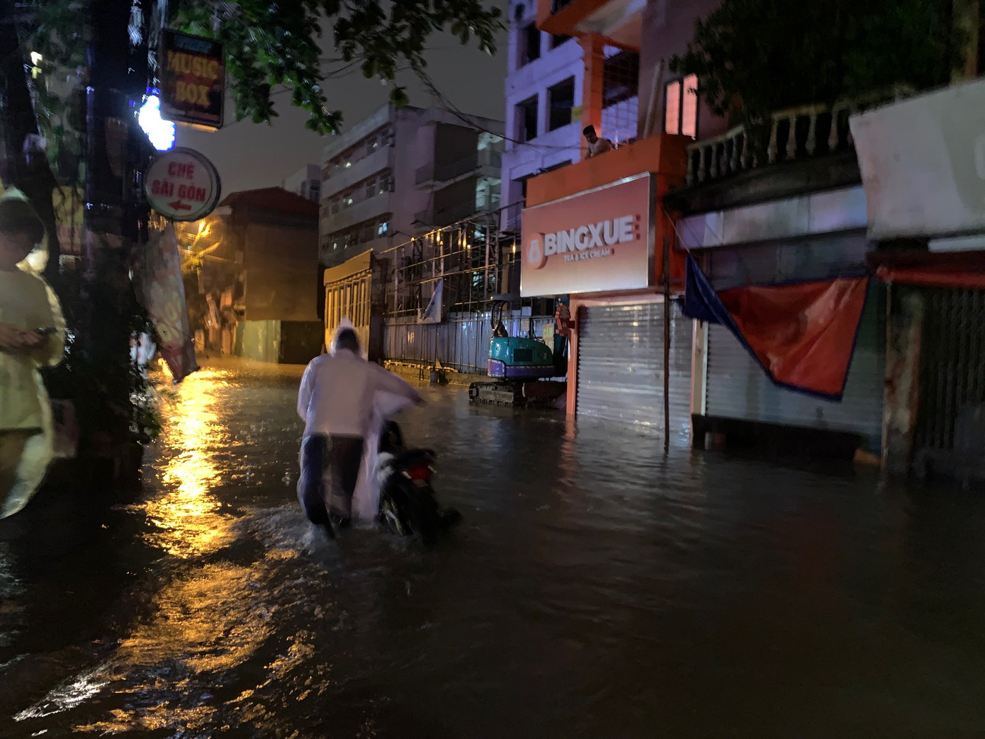 Một người khác cũng phải dắt xe vì phố Triều Khúc ngập sâu tối 7/9. Ảnh: Thái An.