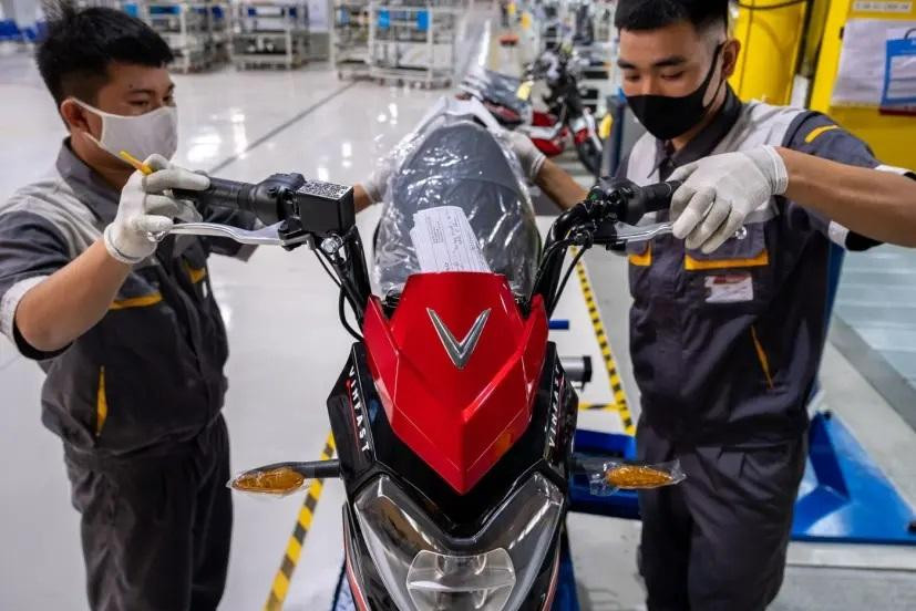Hai công nhân đang lắp xe máy điện VinFast.