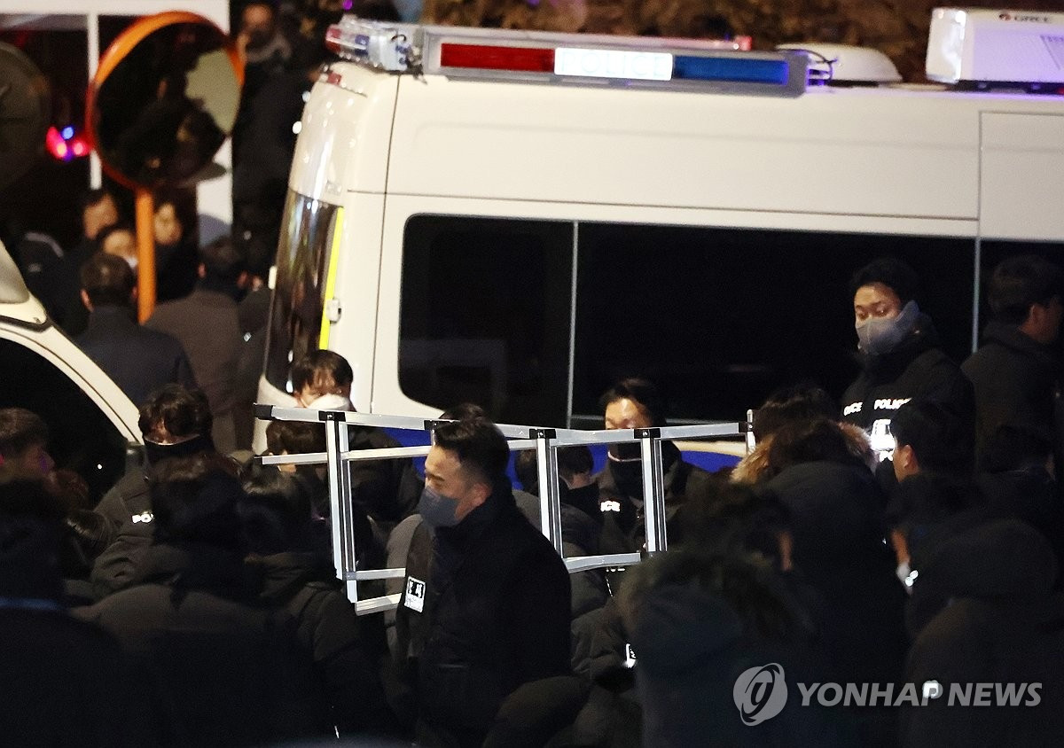 Các điều tra viên dùng thang trèo vào dinh thự tổng thống. (Ảnh: Yonhap)