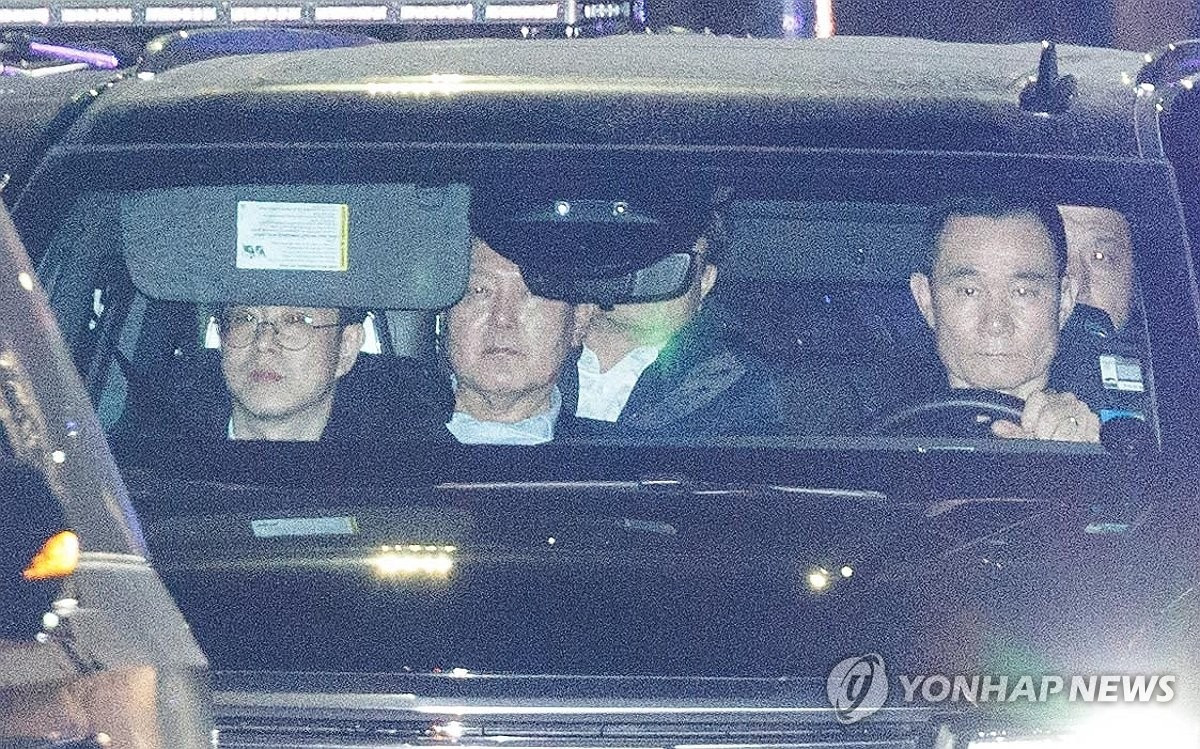 Ông Yoon (giữa) được đưa về trung tâm giam giữ tối 15/1. (Ảnh: Yonhap) Ông Yoon (giữa) được đưa về trung tâm giam giữ tối 15/1. (Ảnh: Yonhap)