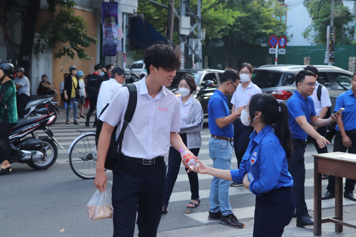 Tình nguyện viên tiếp nước cho thí sinh tại điểm thi ở TP Nha Trang. Ảnh: Khánh Nguyên