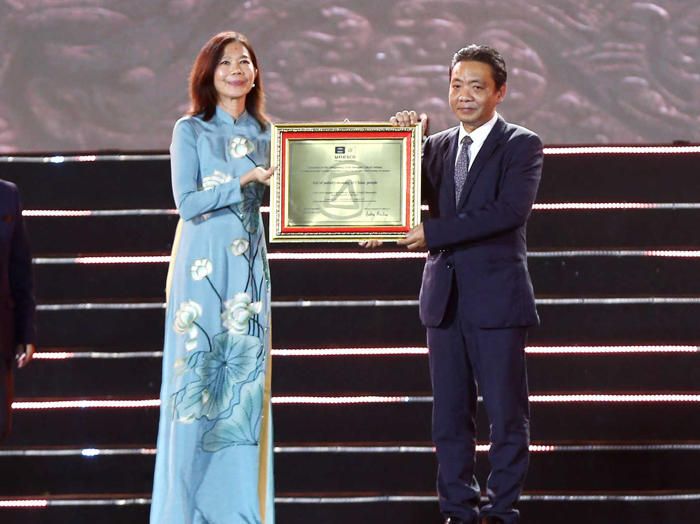 Đại diện UNESCO tại Việt Nam (bìa trái) trao bằng ghi danh “Nghệ thuật làm gốm của người Chăm” vào danh sách Di sản văn hóa phi vật thể cần bảo vệ khẩn cấp tặng đại diện Bộ Văn hoá, Thể thao và Du lịch. (Ảnh: C.H)